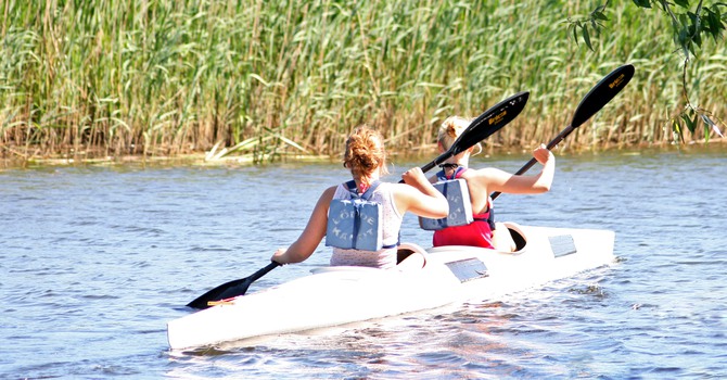 Två ungdomar som paddlar kanot