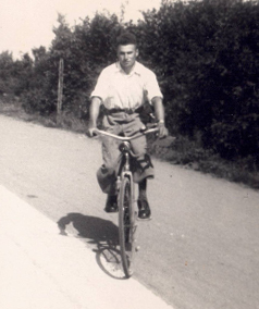 Svartvitt foto på ung man på cykel.