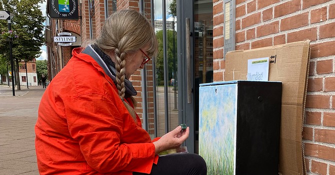 Konstnär som målar ett elskåp i centrala Kävlinge