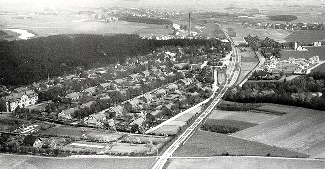 Svart vitt flygfoto över järnvägen och bebyggelse i Furulund.