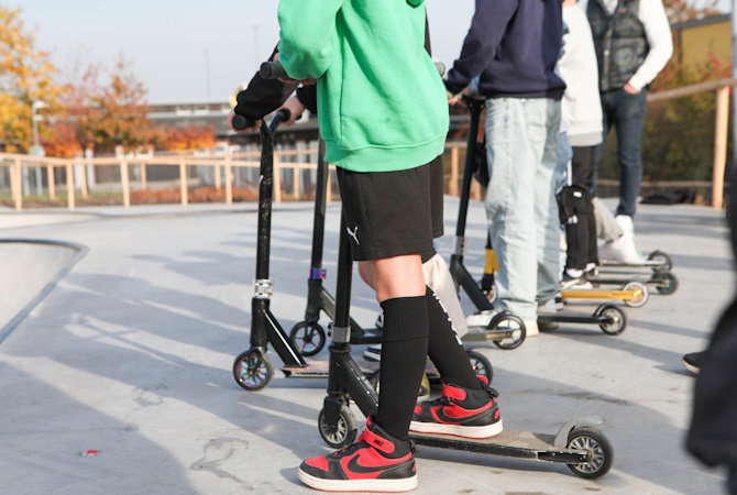 Barn som står med sina kickbikes.